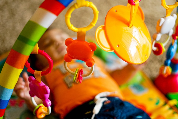 picture of baby on a multy functioning mat with toys around it