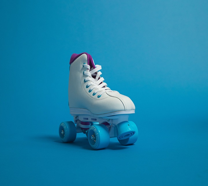 picture of one white roller skate with blue wheels on a blue background 