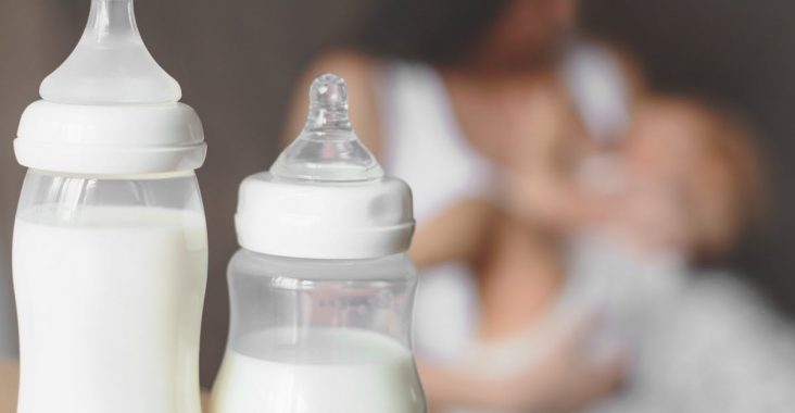woman feeding her baby with bottle of milk