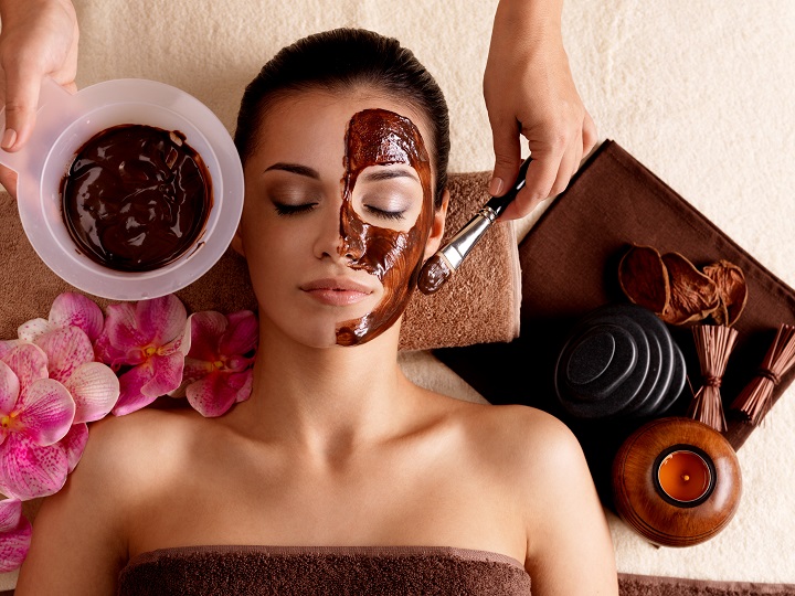 woman getting facial with chocolate cosmetics 