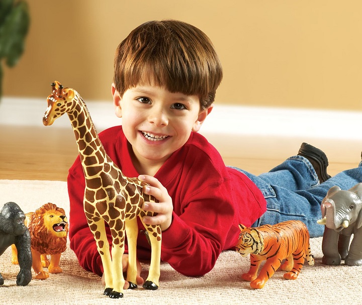 little boy playing with animal figurines 