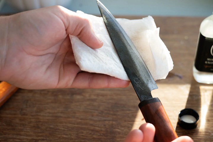 person putting carbon oil on a knife 